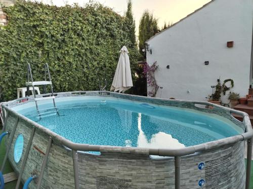 una piscina en un patio con sombrilla en LA CASONA DE VALENZUELA, en Valenzuela