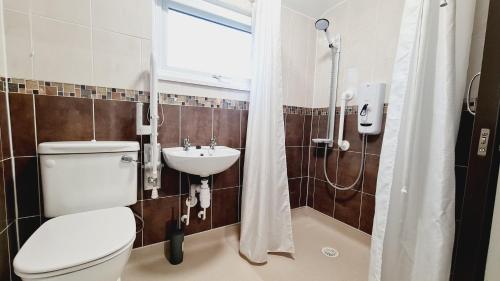 Un baño con inodoro, lavabo y ducha. en Saint Johns 3-bedroom House-Greater London, en Dartford