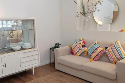 Una sala de estar con un sofá y un espejo. en Sweet Domus & Terrace Citycenter, en Vila Nova de Famalicão