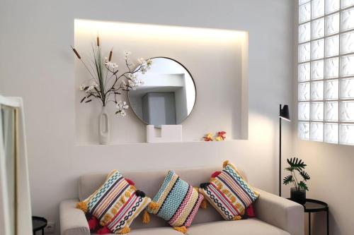 Una sala de estar con un sofá con almohadas y un espejo. en Sweet Domus & Terrace Citycenter, en Vila Nova de Famalicão