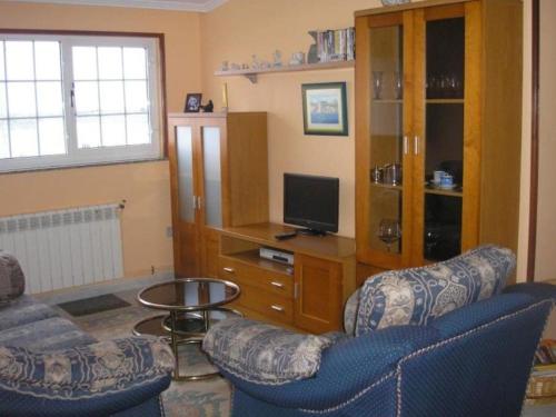 a living room with two chairs and a television at Apartamento en las afueras in Ribadeo