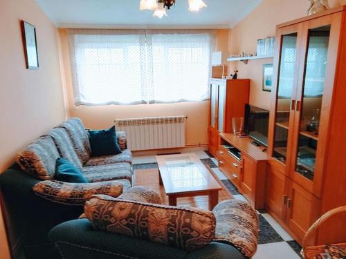 sala de estar con 2 sofás y TV en Apartamento en las afueras, en Ribadeo