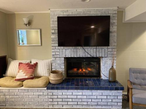 a living room with a fireplace with a tv above it at BlueHaven: Your Cozy Lakeside Retreat in Glenn