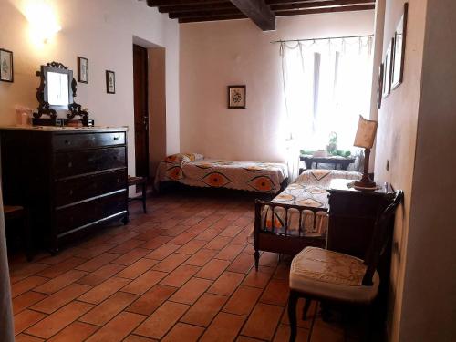 a room with a bedroom with a dresser and a bed at Podere Il Cerrone app Romilda con piscina in Fauglia