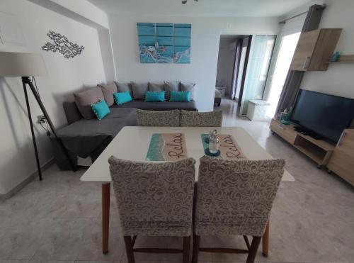 a living room with a table and chairs and a couch at Aegean Blue in Panteli