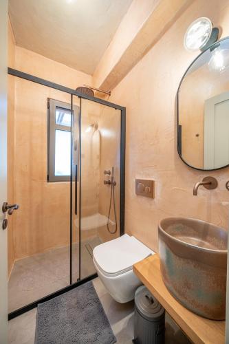 a bathroom with a sink and a toilet and a mirror at Villa Rodamos in Karavomylos