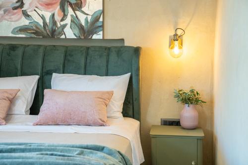 a bed with a green headboard and a pink pillow at Villa Rodamos in Karavomylos