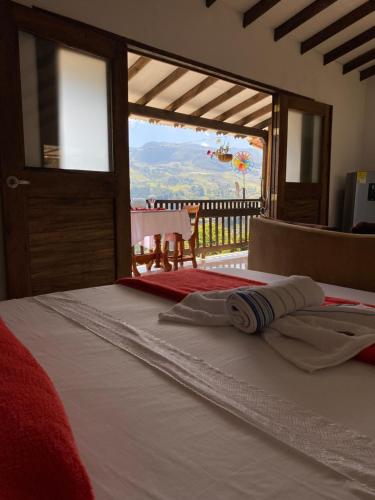 a bedroom with a bed with a view of a balcony at Cabaña Noche De Luna in Jardin