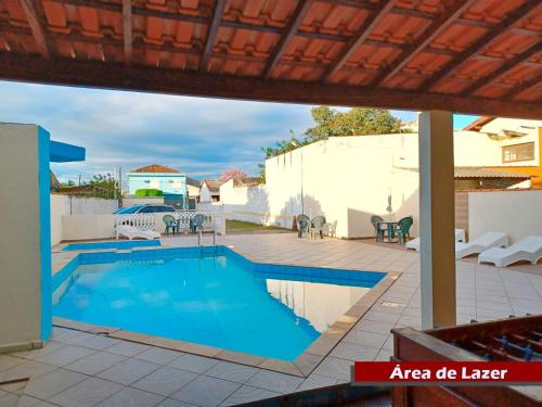 a swimming pool in a yard with a patio at Rial Hotel in Itanhaém