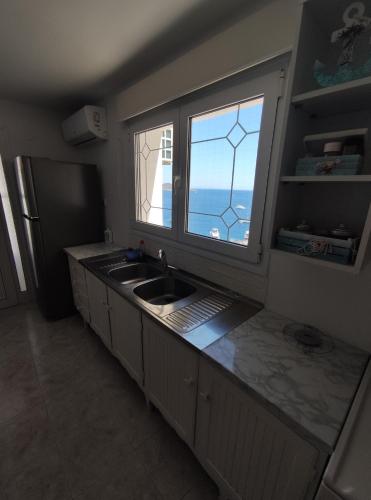 a kitchen with a sink and a window at Aegean Blue in Panteli