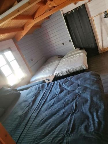 Cette chambre mansardée comprend un grand lit. dans l'établissement La Cabane., à Magné