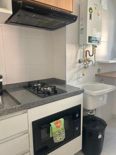 a small kitchen with a stove and a sink at AP Smart Quirino in Campinas