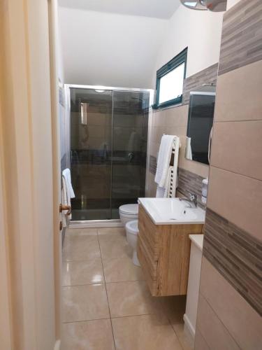 a bathroom with a shower and a toilet and a sink at CASA VACANZA DEL SOLE in Milo