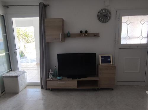 a living room with a flat screen tv and a door at Aegean Blue in Panteli