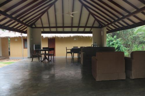 een woonkamer met een tafel en stoelen. bij WildEscape, Yala Blocks 3 & 5 in Buttala Town