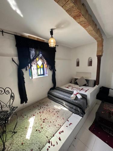 a bedroom with a bed and a window at Dar Touijar in Chefchaouen