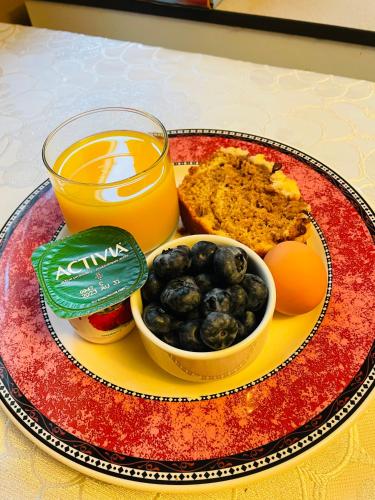 a plate of food with a glass of orange juice and fruit at Garden home in Victoria -Beautiful home in Victoria in Victoria