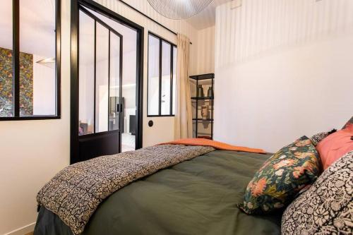 une chambre avec un lit dans une pièce avec des fenêtres dans l'établissement Luxuous loft in the jourdains'village-Imhost, à Paris