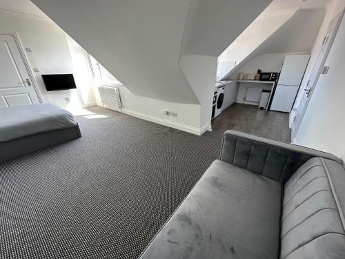 Stylish Modern, 1 Bed Flat, 15 Mins To Central London في هيندون: غرفة معيشة مع أريكة وسرير