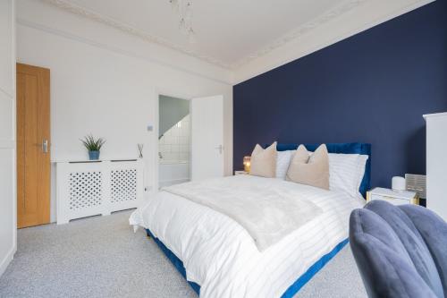 um quarto azul com uma cama branca e uma parede azul em Luxury Central Retreat with Off Road Parking em Southampton