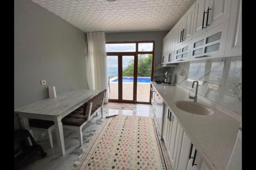 una cucina con tavolo, lavandino e bancone di Kocaeli'nde Körfez Manzaralı Doğayla Başbaşa Tatil a Kocaeli