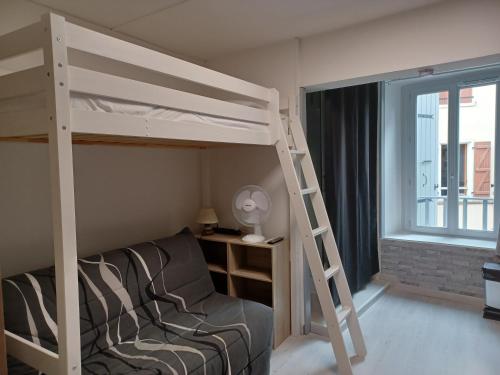 - une chambre avec des lits superposés, une chaise et une fenêtre dans l'établissement Charmant Studio Centre de Foix 2ème étage, à Foix