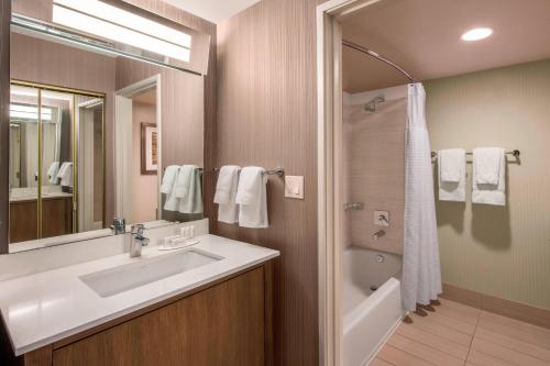 uma casa de banho com um lavatório, um espelho e um chuveiro em Courtyard by Marriott Henderson - Green Valley - Las Vegas em Las Vegas
