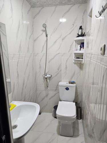 a white bathroom with a toilet and a sink at Galstyans HOTEL EVN Airport in Yerevan