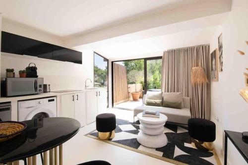 eine Küche mit einem Wohnzimmer mit einem Sofa und einem Tisch in der Unterkunft Golfe St Tropez 3 pièces à 2 min de plage in Sainte-Maxime