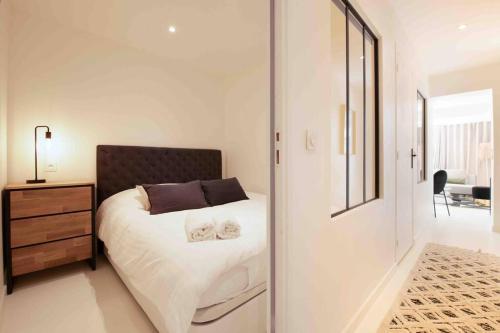 Schlafzimmer mit einem Bett, einer Kommode und einem Spiegel in der Unterkunft Golfe St Tropez 3 pièces à 2 min de plage in Sainte-Maxime