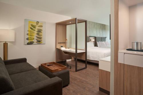 Habitación de hotel con sofá y cama en SpringHill Suites by Marriott Orlando Lake Nona en Orlando