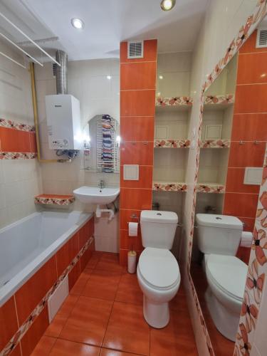 een badkamer met een toilet, een wastafel en een bad bij Mieszkanie 200m od jeziora in Szczytno