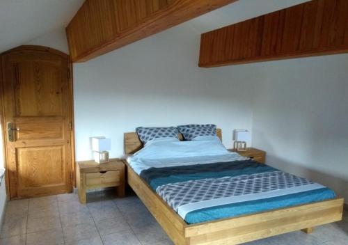 une chambre avec un lit et une armoire en bois dans l'établissement Gîte le Soleirol, à Malbosc