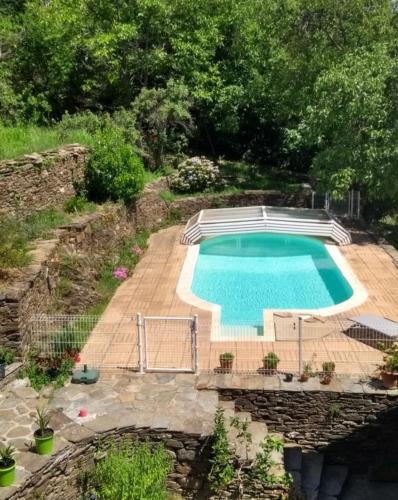 une piscine dans un jardin à côté de l'aickedickedicked dans l'établissement Gîte le Soleirol, à Malbosc