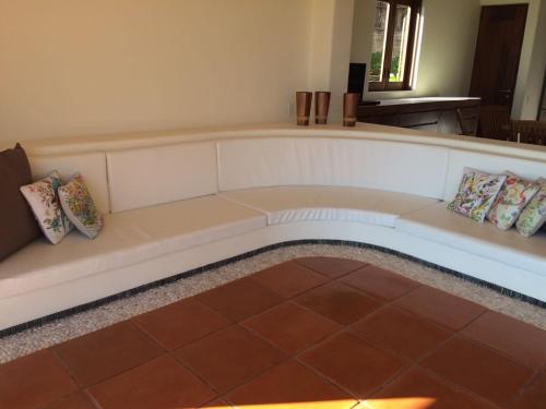 a white couch with pillows on it in a room at Condo BEACH FRONT PLAYA BLANCA GARDEN in Zihuatanejo