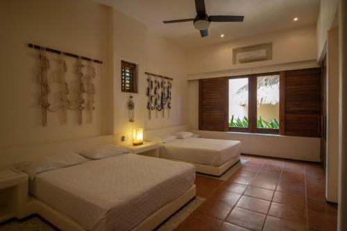 a bedroom with two beds and a window at Condo BEACH FRONT PLAYA BLANCA GARDEN in Zihuatanejo