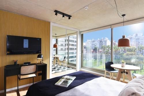 ein Schlafzimmer mit einem Bett und einem großen Fenster in der Unterkunft Vistas Panorámicas al Parque in Montevideo