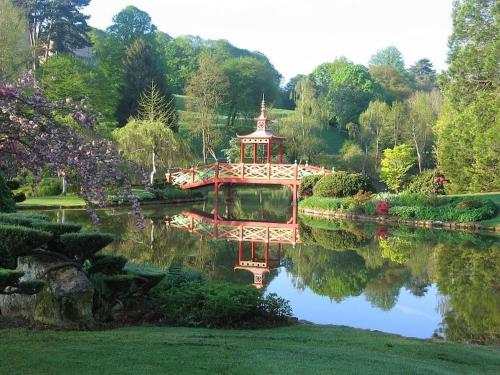 einen Garten mit einer roten Brücke in der Mitte eines Sees in der Unterkunft Maison au calme avec Jardin proche Paris-Bercy in Charenton-le-Pont