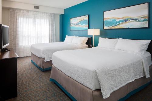 a hotel room with two beds and a flat screen tv at Residence Inn by Marriott Orlando at SeaWorld in Orlando