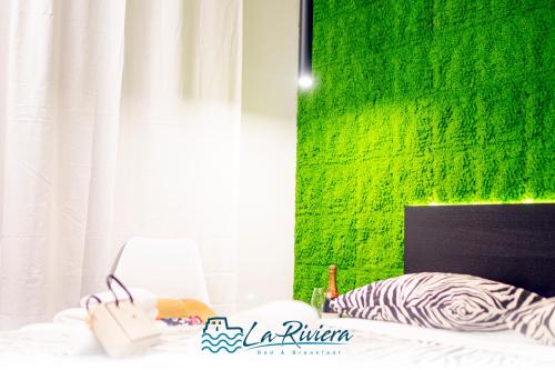 a bedroom with a green wall and a bed at La Riviera in Scalea