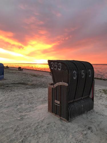 a stack of luggage sitting on the beach at sunset at Ferienhaus Sonnendeck in Dornum