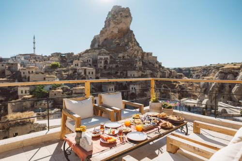 a table on a balcony with a view of the mountain at Vie Cappadocia - Adults Only in Nevşehir