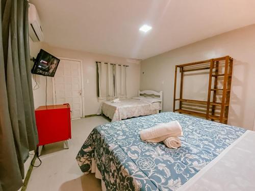 a bedroom with two beds and a tv in it at Garden 437 Suítes in Florianópolis