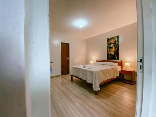 a bedroom with a bed and a table with two lamps at Garden 437 Suítes in Florianópolis