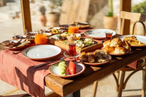 a wooden table with plates of food on it at Vie Cappadocia - Adults Only in Nevsehir
