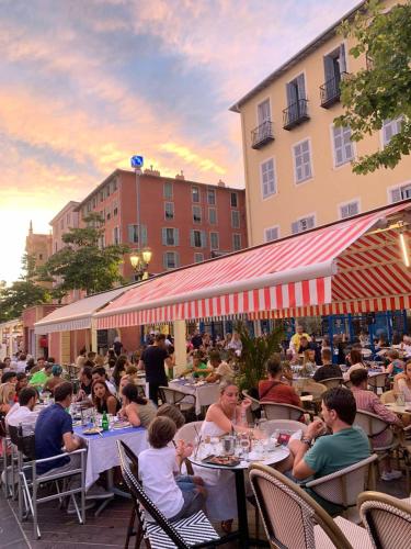 un groupe de personnes assises à des tables dans un restaurant en plein air dans l'établissement Apartment 33 on The Old Historic Senate Square, à Nice