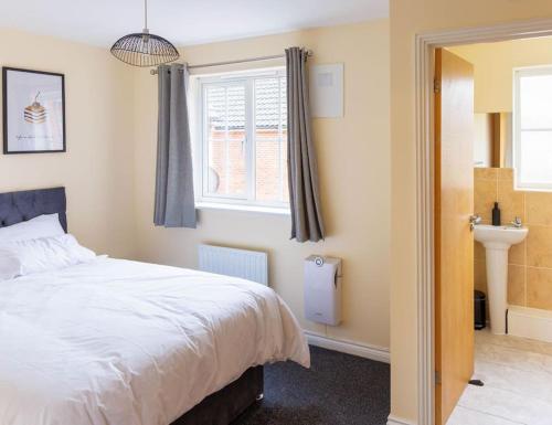 a bedroom with a white bed and a window at Stylish 3 Bedroom and free parking in Thamesmead