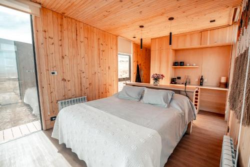 a bedroom with a bed in a room with wooden walls at Hotel De Cielo in Tupungato