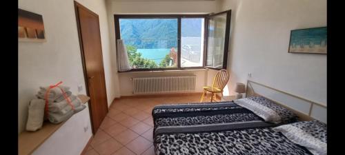 una camera con letto e finestra di casa camelie a Pino Lago Maggiore