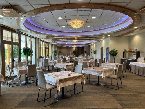 une salle à manger avec des tables et des chaises et un grand plafond dans l'établissement Hotel Venko, à Dobrovo